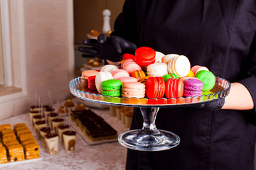Colorful macaroons and other desserts served on the table