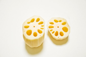 Two cut lotus roots on a white background