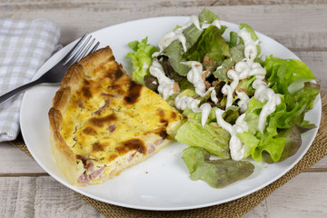 part de quiche lorraine et salade dans une assiette