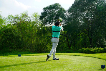 Blurred golfer playing golf in beautiful golf course in the evening golf course with sunshine in...