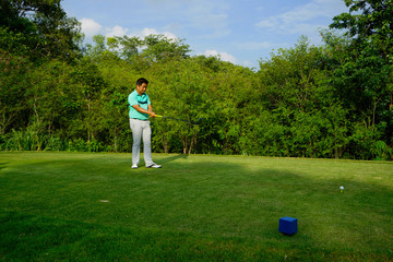 Blurred golfer playing golf in beautiful golf course in the evening golf course with sunshine in...