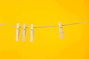 Wooden clothespins hanging on a clothesline rope