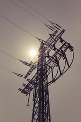 High-voltage power line tower carry green electricity sun energy. Ironman business is transmission...