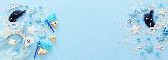 Purim celebration concept (jewish carnival holiday) over pastel blue wooden background. Top view, Flat lay