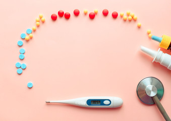 multicolored pharmaceutical pills thermometer, bottle, phonendoscope on a pink background. Copy space. the concept of health. concept  of life. assorted medicines. bright pills. coronavirus