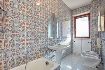 Bathroom interior with floral tiles, sunlight