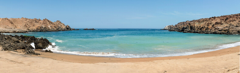 Clean and calm beach with turquoise water at Puerto Inca in Arequipa-Perú.