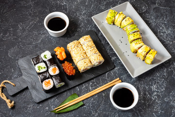 Fototapeta na wymiar Various kinds of sushi served on black stone background