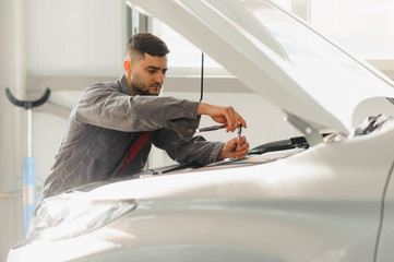 Male and female mechanics working on car