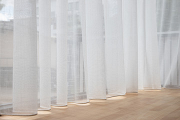 Fototapeta na wymiar white blind curtain above wooden floor at glass window.