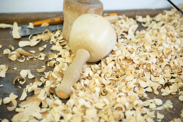 Schnitzklüpfel, anderes Holzbearbeitungswerkzeug und Holzspäne auf einer hölzernen Werkbank