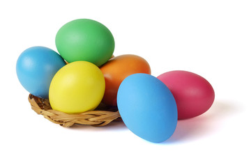 Easter eggs in the basket on the white surface