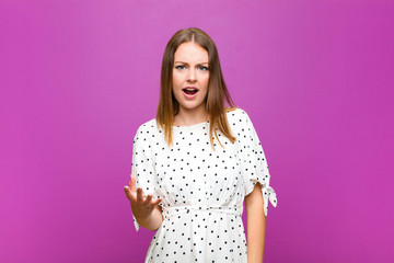 red head pretty woman looking angry, annoyed and frustrated screaming wtf or what‚Äôs wrong...