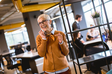 Senior businesswoman using mobile phone at office