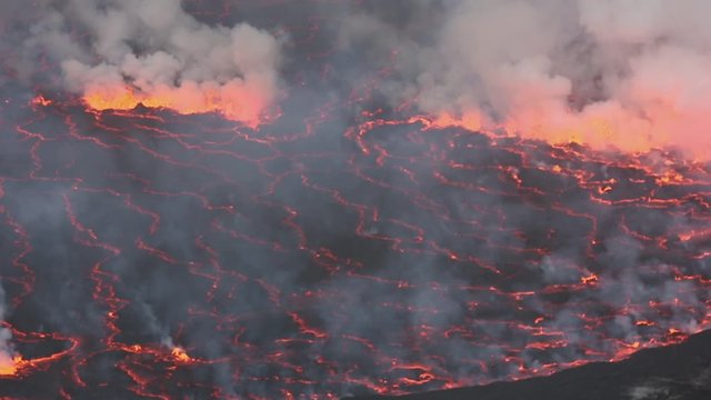 Bubbling lava and smoke in a round crater of Nyiragongo volcano, Congo