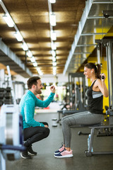 Obraz premium Młoda piękna kobieta robi ćwiczenia z osobistym trenerem