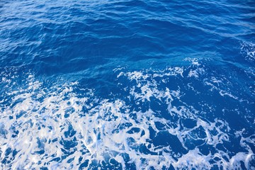 Sea blue water with a turquoise hue with waves and foam. Background image
