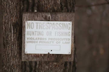 No Trespassing sign posted for rural wooded property, winter, snow