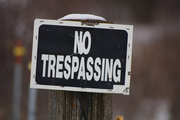 No Trespassing sign posted for rural wooded property, winter, snow