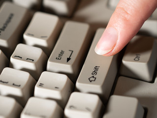 Female forefinger pushes RIGHT SHIFT button. Close-up