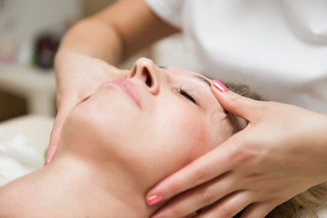 Closeup face of  a woman having facial massage at spa
