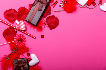 Table top view image of decoration valentine's day background concept. Flat lay arrangement of red shape & gift box with essential items on modern pastel pink paper with middle space for text.
