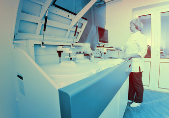 a female scientist near the analyzer in a medical microbiological laboratory. Equipment for analysis, DNA, PCR