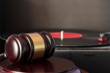 Judge's gavel and vinyl record player. Concept of entertainment lawsuit, music piracy and copyright protection