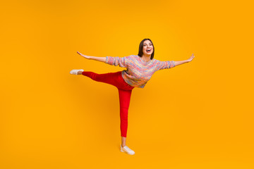 Full size photo of dream dreamy girl enjoy free time holiday hold hand fly like bird do gym exercises wear pullover sneakers isolated over yellow color background
