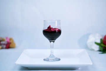 A wine glass with a red rose in the glass