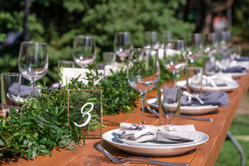 Preparing for an open-air party. Decorated with fresh flowers served tables. Table number. Decoration Details