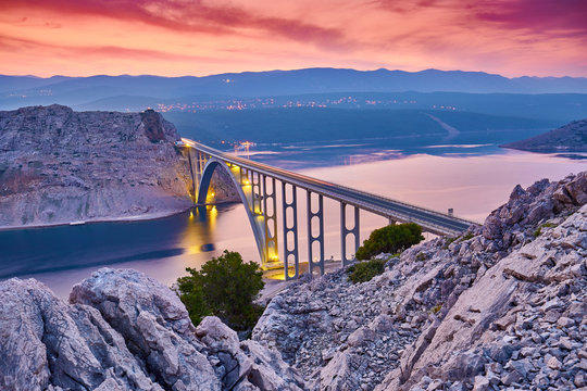 Dramatic summer seascape of Adriatic sea. Bigger arch Bridge to Krk Island at sunrise, near Maslenica, Croatia, Europe.  Bridge connects the Croatian island of Krk with the mainland. Morning light.