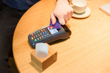 Close up of customer paying by card contactless payment
