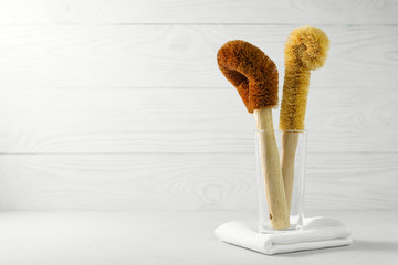 Two coconut scrapers with a bamboo handle in a glass cup on a light background. Biodegradable...