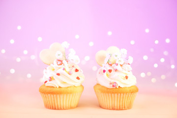 Two cupcakes with white cream with pink decoration for Valentine's Day.