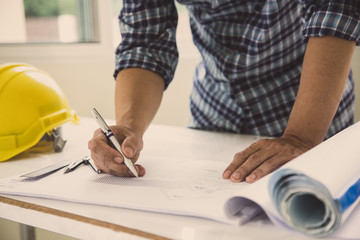 architect man handwriting with blueprint to build houses. After agreeing the employment price the cost of construction and repair real estate