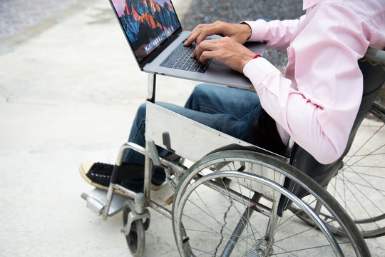 Disabled man is wheelchair finding information on notebooks at home.Disabled concept