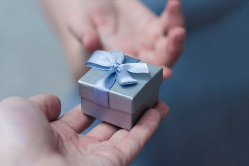 hands giving and receiving a present, close up.