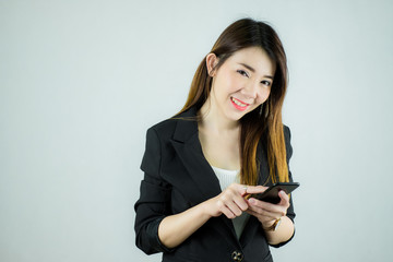 Portrait of beautiful asian business woman holding touching a mobile phone and smiling. Caucasian female model isolated on white background.
