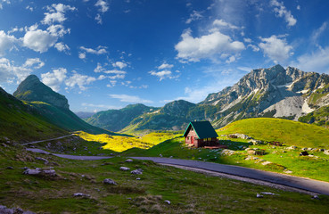 Amaizing sunset view on Durmitor mountains, National Park, Mediterranean, Montenegro, Balkans, Europe.  Bright summer view from Sedlo pass. Instagram picture. The road near the house in the mountains - obrazy, fototapety, plakaty