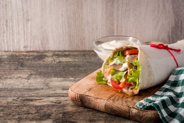 Doner kebab or shawarma sandwich on wooden table. Copy space