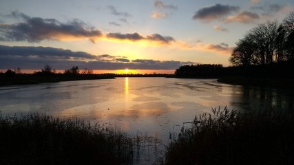 Zachód słońca nad zamarzniętym jeziorem