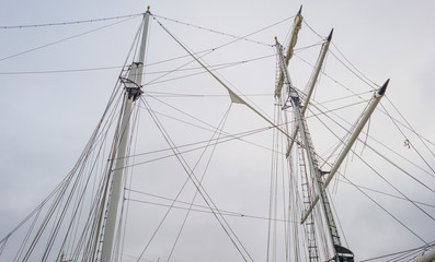 Rigging of a tall ship below a blue cloudy sky in sunlight in winter