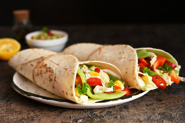 Mexican tortilla with beef, corn and vegetables with guacamole sauce on a concrete background.