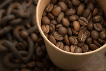  Coffee beans in a paper cup close-up. The aroma of coffee, selected beans, arabica, energy, relaxation, pleasure.