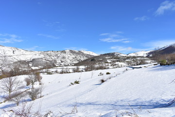 Fototapeta na wymiar Winter landscape with white snowy mountains and blue sky. Piornedo, Ancares, Lugo, Galicia, Spain.