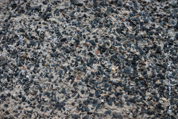 Dark stones in concrete. Stone wall. Rock