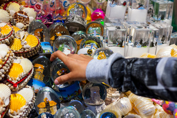 Child's hand grabbing snowglobe souvenir