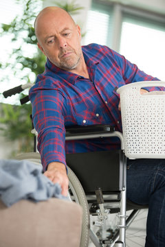 disabled man on wheelchair doing laundry