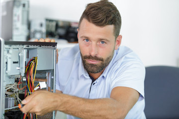 an electronic male worker repairs a pc